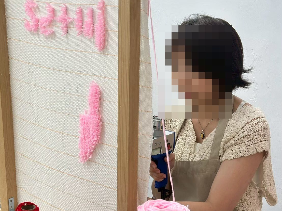 學員用簇絨槍把粉色毛線打進底布